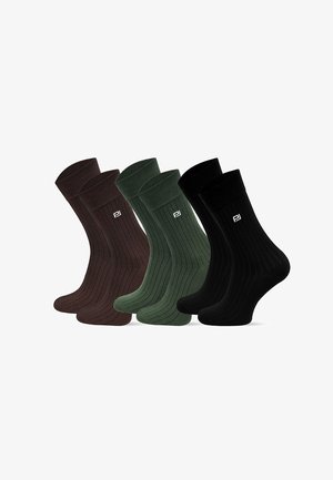 Trzy pary żeńskich skarpetek o ryflowanym wzorze w ciemnym brązie, oliwkowej zieleni i czerni, z małym białym logo w okolicy kostki. Miękki, elastyczny materiał.