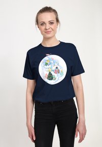 Camiseta de manga corta azul marino con un gráfico circular que presenta un castillo nevado, un árbol de Navidad y personajes coloridos en una escena invernal.