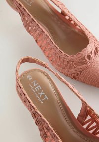 Roze geweven slingback damesschoenen met lage hakken, waarvan er één de gewatteerde binnenzool toont met het merk "NEXT Forever Comfort," maat 40.