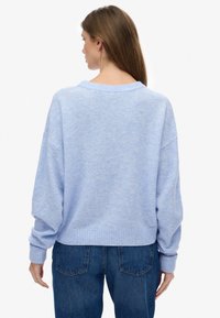 Jasnoniebieski, oversize'owy sweter z prążkowanym dołem i mankietami. Miękka faktura i opuszczone ramiona, z szerokim dekoltem i minimalistycznym designem.