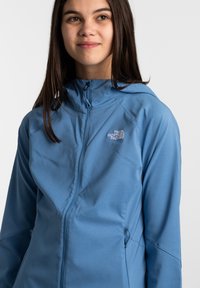 Helleblaue Zip-Hoodie mit tailliertem Design, Kapuze und dem North Face Logo auf der Brust. Glatte Textur und elastischer Stoff.