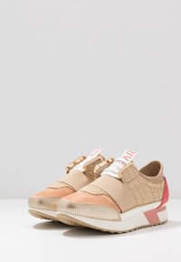 Sport sneakers med en blandning av beige textil, rosa detaljer och guldfärgade metalldelar, med en strukturerad ovandel och elastiska band för en bra passform.
