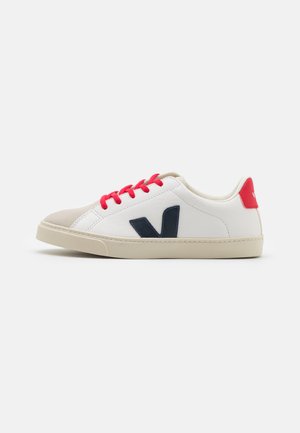 Sneakers bianchi con lacci rossi, logo blu navy e punta in taupe. Parte superiore in pelle liscia e suola in gomma, caratterizzati da un design minimalista.