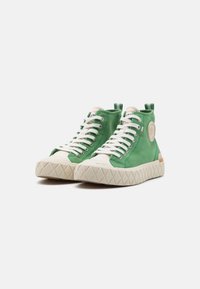 Sneaker alte in tela verde con suola in gomma bianca, grip testurizzato e toppa con logo. Presenta lacci tradizionali e accenti a contrasto.