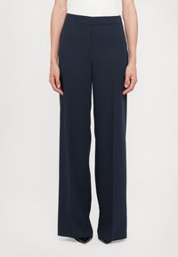 Navy wide-leg trousers made of smooth fabric, featuring a flat waistband and a sleek design that falls straight from the hips to the ankles.
