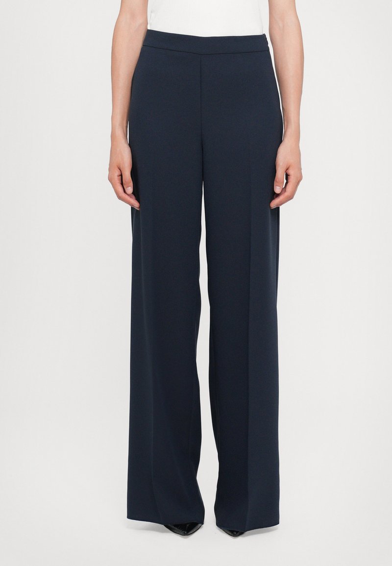 Navy wide-leg trousers made of smooth fabric, featuring a flat waistband and a sleek design that falls straight from the hips to the ankles.