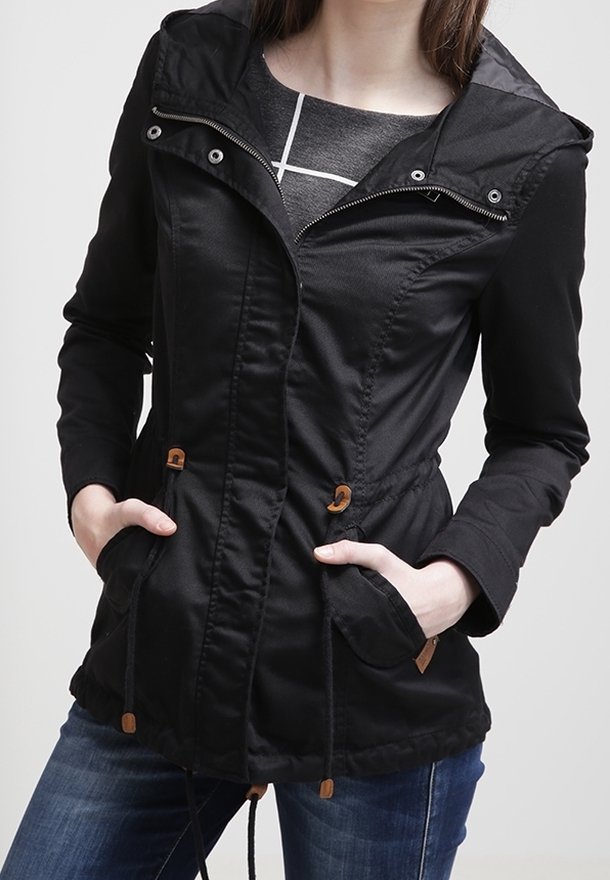 Czarna lekka kurtka z kapturem, zapinana na zamek z przodu, ze ściągaczem w talii i dwoma przednimi kieszeniami. Posiada drewniane troczki i teksturowaną tkaninę.