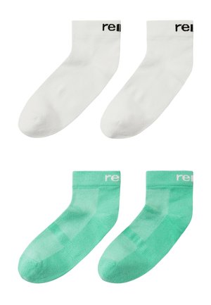 Deux paires de chaussettes basses, une blanche et une turquoise, chacune avec un texte partiel noir ou blanc près du bord-côte.