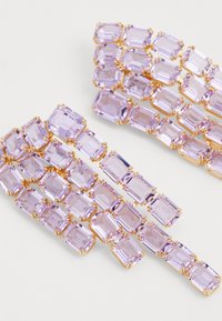 Clipe de păr din piatră prețioasă violet, cu pietre dreptunghiulare montate în metal de ton auriu. Mai multe pietre aranjate într-un design stratificat și în cascade.