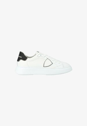 Baskets blanches avec un dessus en cuir lisse, bout arrondi et une semelle blanche texturée. Présentent un accent de talon noir contrastant.