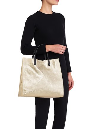 Gouden metallic tote bag met een gladde textuur, zwarte handvatten, rechthoekige vorm en zonder zichtbare patronen of hardware-details.