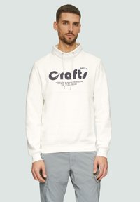 Witte hoodie met een hoge kraag, voorzien van een donker grafisch print op de borst en trekkoordaccenten. Zachte textuur, ribgebreide manchetten.
