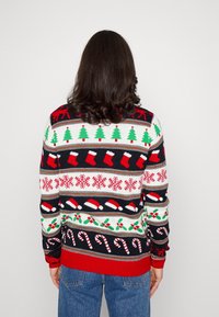 Sweter świąteczny z dzianiny, z wielokolorowym wzorem przedstawiającym drzewa, skarpety, płatki śniegu i laskę cukrową na czarnym tle.