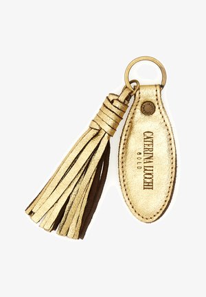 Portachiavi in pelle dorata con nappina, targhetta ovale con la scritta "CATERINA LUCCI GOLD" e anello portachiavi in metallo attaccato, su sfondo bianco.