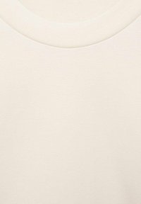 Svijetlo bež majica od sweatshirt tkanine sa mekom teksturom, s okruglim izrezom i glatkom, ujednačenom površinom bez uzoraka ili akcenata.