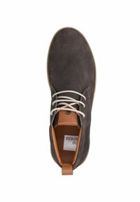 Donkergrijze geperforeerde leren schoen met lichtbruine accenten en veters, met een platte rubberen zool en een lus bij de hiel voor gemakkelijk aan- en uittrekken.