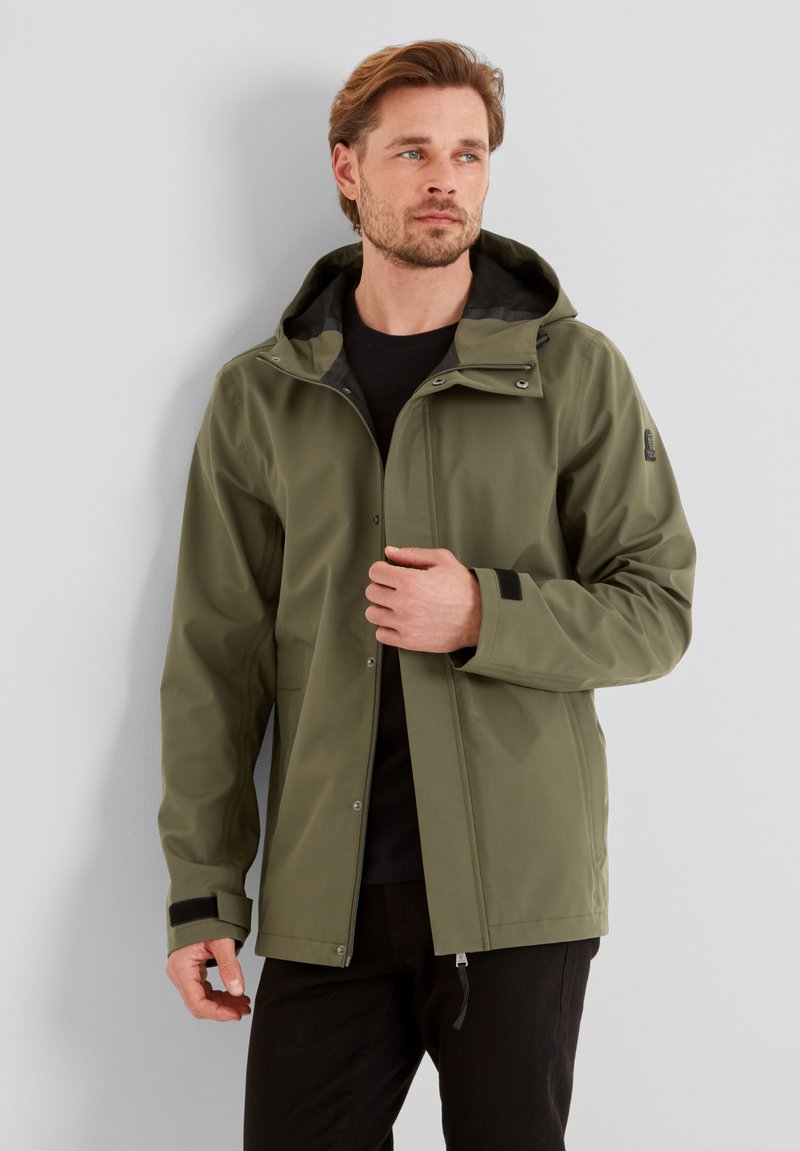 Olive green waterproof jacket with a hood, featuring snap closures, adjustable cuffs, and a black lining. Two front pockets are present.