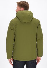 Olivgrön jacka med huva, strömlinjeformat design och slät yta; har en lätt nedhasad bakparti och tryckknappar på axlarna.