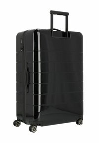 Valigia nera rigida con finitura lucida, design a coste, manico retrattile e quattro ruote per la mobilità. Dispone di una serratura a combinazione.