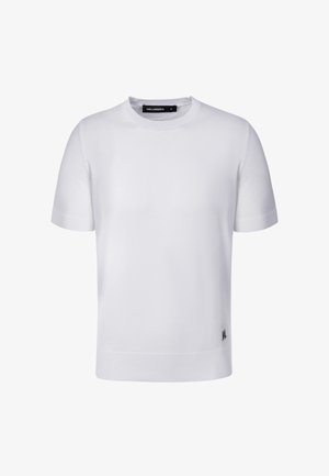 Weißes kurzärmliges Strick-T-Shirt mit Rundhalsausschnitt, geripptem Kragen und Bündchen, mit kleinem schwarzem Logo nahe dem unteren Saum auf der Vorderseite.