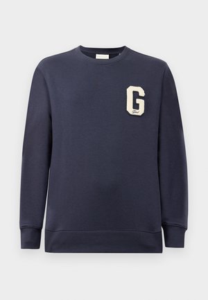 Sweatshirt bleu marine en mélange de coton, avec un col et des poignets côtelés, orné d'un patch "G" crème sur la poitrine.