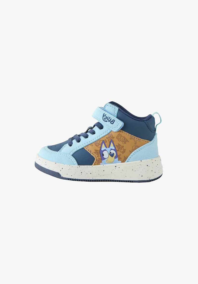Baskets montantes pour enfants bleu et beige avec un personnage de chien de dessin animé, bracelet bleu clair, lacets bleu foncé et semelle blanche tachetée.