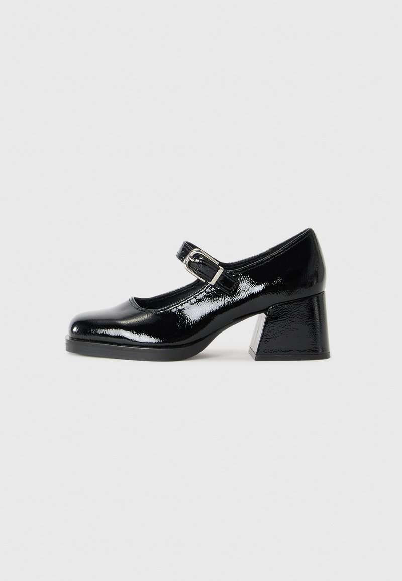 Chaussures Mary Jane en cuir verni noir avec un bout rond, une bride à boucle réglable et un design à talon bloc.
