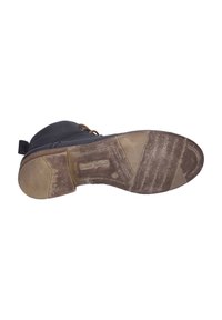 Semelle de bottes en cuir noir usées avec des crampons visibles, nom de la marque "Josef Seibel" embossé au milieu de la semelle.