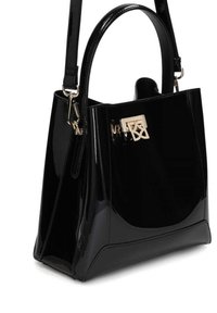 Sac à main noir brillant avec poignées supérieures, bandoulière amovible et fermoir géométrique doré à l'avant.