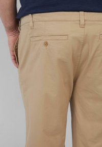 Khaki broek met een gladde textuur, voorzien van een achterzak met knoopsluiting en een vlakke tailleband. Minimalistisch ontwerp, rechte pijp.