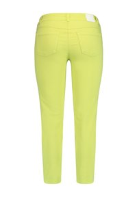 Světlé žluté kalhoty s přiléhavým střihem, které mají dvě zadní kapsy a hladkou texturu. Spodní lem je mírně zkrácený.
