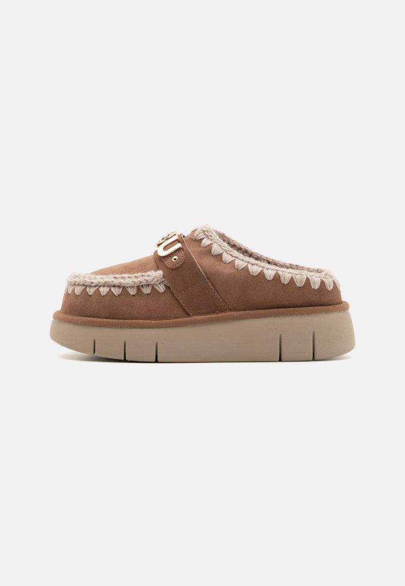 Smeđi nubuk slip-on cipele s bež gumenim potplatom, kontrastna pletena detalj na vrhu i dekorativna kopča.