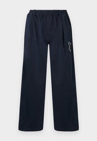 Námořnické modré kalhoty s širokými nohavicemi vyrobené z hladké tkaniny. Mají elastický pás a jemný vyšívaný design na levé nohavici.