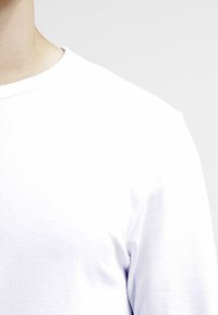 Weißes Baumwoll-T-Shirt mit Rundhalsausschnitt und kurzen Ärmeln, das eine glatte Textur aufweist und keine sichtbaren Logos oder Muster hat.