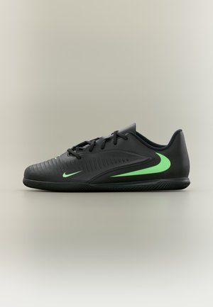 Čierna nízka športová obuv s zelenými logami Nike a textúrovanými detailmi na neutrálnej farbe pozadia, bočný pohľad.