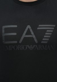 Czarny bawełniany t-shirt z dużym, wytłoczonym szarym logo z napisem "EA7" i "EMPORIO ARMANI", ozdobiony poziomymi paskami.