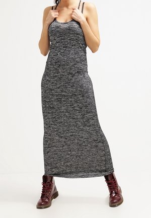 Grå melange maxiklänning med figurnära bodice, tunna axelband och sidoslitsar, i kombination med bärnstensfärgade snörboots. Mjuk, strukturerad tyg.