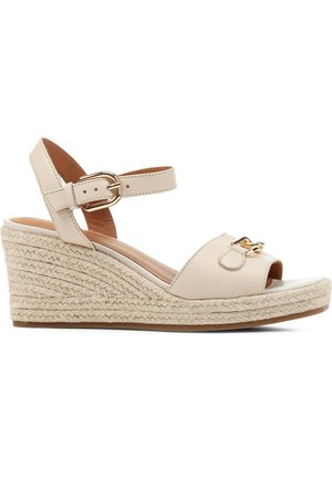 Beige Keilsandalen mit einem Obermaterial aus Leder, offenem Zehenbereich, verstellbarem Knöchelriemen und einer geflochtenen Jutefußbett mit goldenen Hardware-Akzenten.