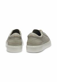 Light gray leather sneakers with a textured finish, white rubber sole, and subtle branding on the back. Features rear zipper and accents.