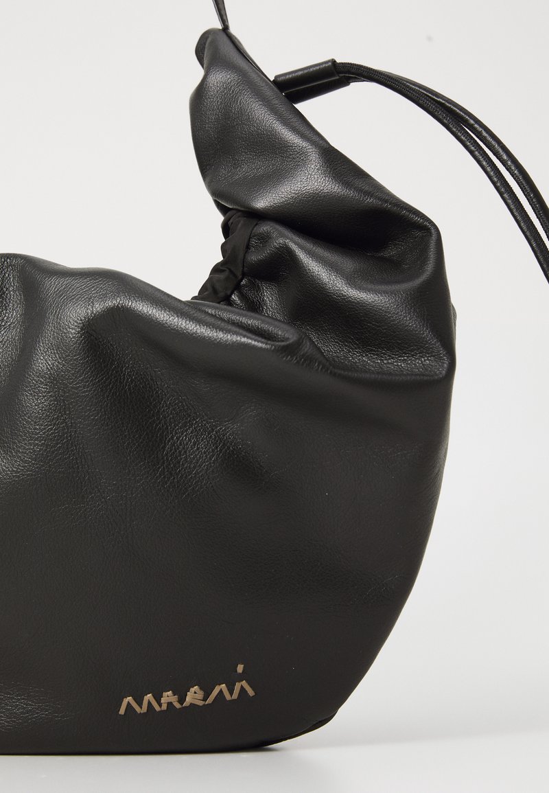 Borsa a spalla in morbida pelle nera con dettagli arricciati e tracolla sottile, caratterizzata da un piccolo logo metallico del marchio vicino al bordo inferiore.