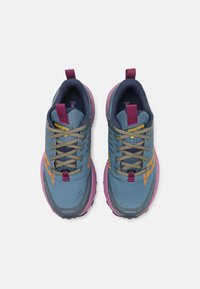 Baskets de sport bleues et violettes avec un matériau texturé, des accents jaunes, des lacets gris et une languette, dotées d'une semelle robuste pour une meilleure adhérence.