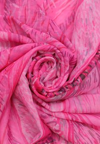 Tessuto leggero e trasparente di colore rosa con vari motivi astratti in tonalità di rosa scuro e viola, disposti in una formazione a spirale.