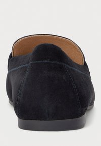 Marineblauwe suède loafers met een soepele textuur, ronde neus en minimalistisch ontwerp. Voorzien van een contrasterende stiknaad en een platte rubberen zool.