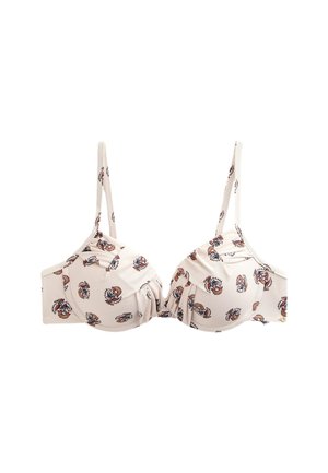 Zbliżenie białego topu bikini w kwiatowy wzór z miękkimi marszczeniami i cienkimi ramiączkami na osobie o średnim odcieniu skóry.
