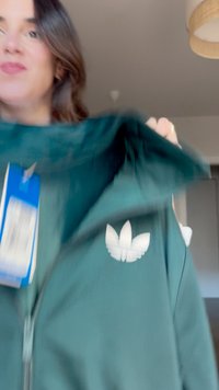 Green zip-up hoodie made of soft fabric. Features a white embroidered logo on the left side. Includes a tag showing brand and size.