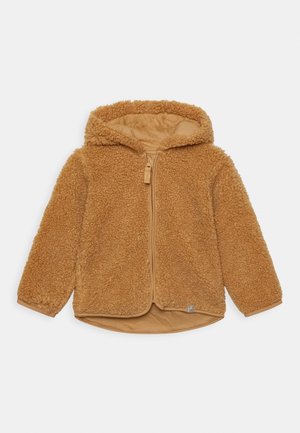 Veste à capuche marron duveteuse avec fermeture éclair devant, manches longues et ourlet légèrement arrondi, présentée sur un fond clair uni.