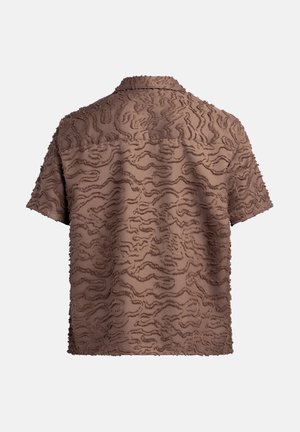 Camisa de manga corta de color marrón con un patrón de ondas texturizadas, que presenta un material suave y esponjoso y un diseño de cuello clásico.