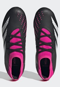 Schwarze und pinke Fußballschuhe verfügen über eine strukturierte Oberfläche, silberne Akzente und einen engen Sitz mit schwarzen Schnürsenkeln und einer pinken Mesh-Zunge.