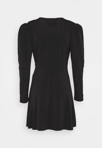 Černé šaty s dlouhými rukávy, přiléhavým korzetem a rozšířenou sukní. Hladká textura a minimální zdobení, vytvářející elegantní siluetu.