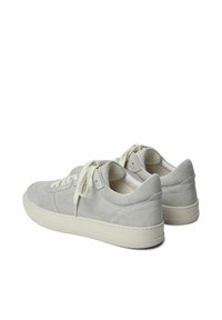 Hellgraue Wildledersneaker mit einer dicken weißen Gummisohle, ausgestattet mit beigen Schnürsenkeln und minimalistischen Designelementen. Akzente sind die Nähedetails.